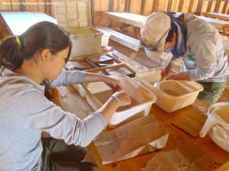 Tokiko Fujisawa and Emi Watanabe washing artifacts from the Block 17 garden pond dig at the mess hall in the demonstration block. Photo by Laura Ng, courtesy of NPS.
