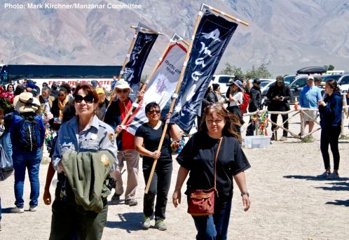 Banners representing the 10 American concentration camps, the Crystal City Internment Camp, and the 442nd/100th/MIS during a processional to the Manzanar cemetery