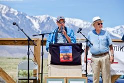 Manzanar Committee Co-Chair Bruce Embrey (center), shown here with Co-emcee Warren Furutani (right), during the 50th Annual Manzanar Pilgrimage, April 27, 2019, at the Manzanar National Historic Site.